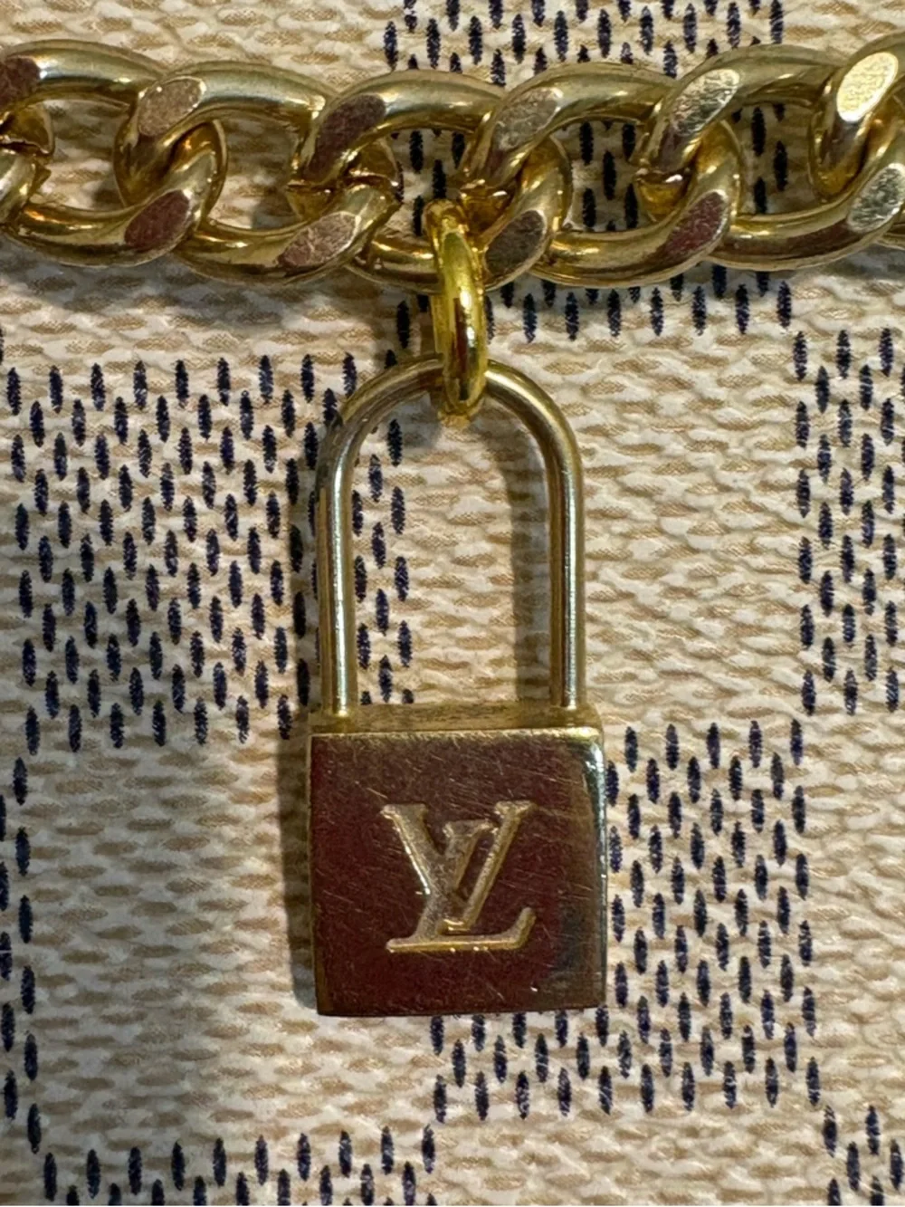 Authentic Louis Vuitton Lock Charm and other unbranded charms on bag chain